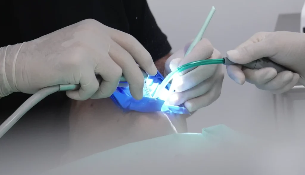 Procedimento dentário em paciente com dentista e auxiliar
