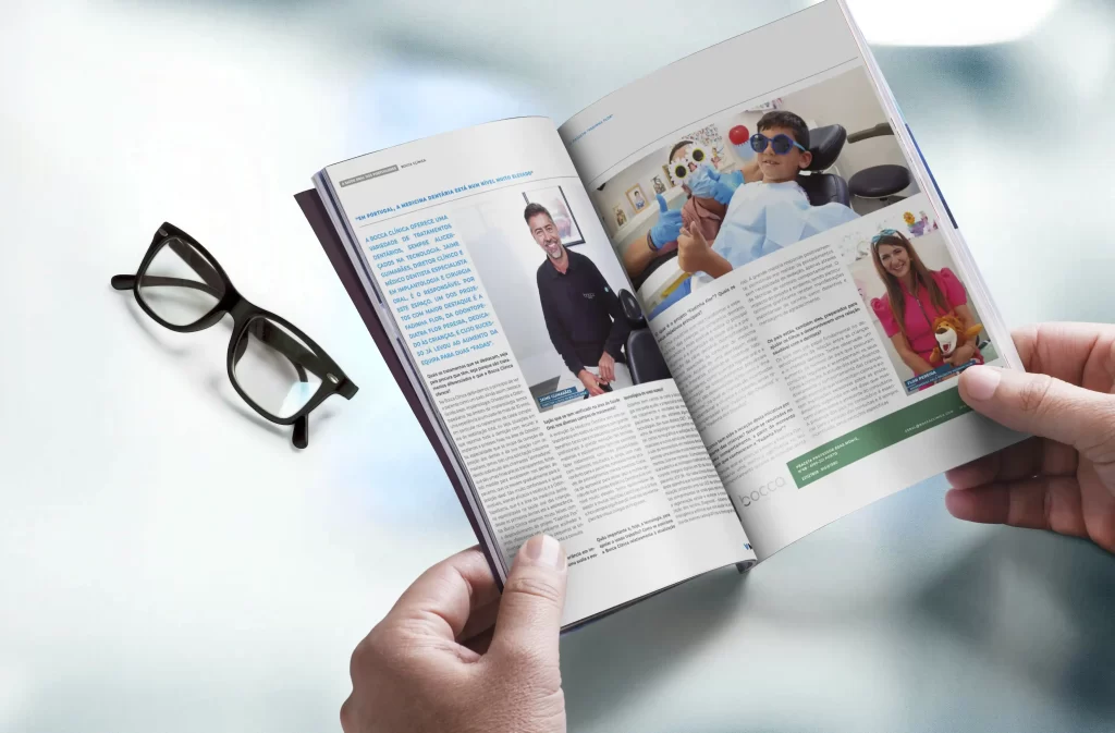Pessoa a segurar uma revista com destaque para a entrevista da Bocca clínica.